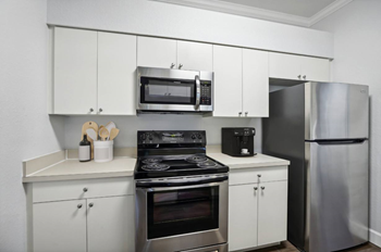 A modern kitchen with stainless steel appliances and white cabinets.